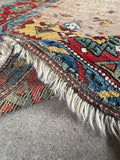 Antique tribal hallway runner, collectible Caucasian hand knotted wool rug with a floppy handle, faded ivory ground, vegetable dyed wool, and genuine old-world character.