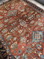 Warm-toned Heriz rug with angular vines and stylized palmettes