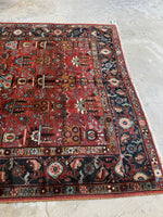 Heriz rug showing strong contrast between rust field and midnight border.