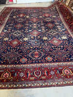 Full view of large antique 1920s Persian Heriz rug with tribal design.