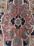 Antique Heriz rug showing softened sun washed palette and age.
