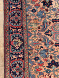 Authentic 100 year old Persian rug side view capturing border pattern.