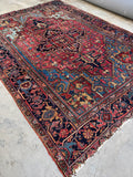1920s Persian Heriz rug 7’ x 9’9 with bold angular medallion in watermelon red and sky blue tones.