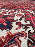 Antique Heriz carpet with ivory corner spandrels and a graphic oversized layout.
