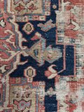 Handwoven antique Persian Heriz rug wool detail with visible history.