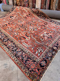 Antique Persian tribal area rug 8x10 full top-down view showing a bold terracotta field and allover geometric layout.