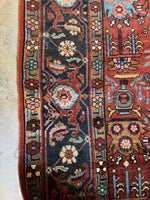 Midnight blue border of antique Heriz rug with turtle motifs and floral elements.