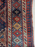 Antique tribal Kazak rug with security fence border motif.