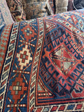 Antique Kazak rug with ram’s horn symbols and strong geometric medallions.