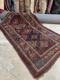Antique Kazak rug from early 1900s with five pole medallions on deep navy ground.