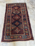 Early 1900s handwoven Kazak rug with ram’s horn motifs and tribal medallion field.