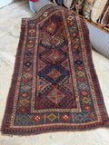 Handwoven antique Kazak rug showing five stacked medallions and geometric motifs.