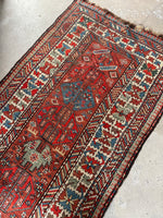 Kazak runner with bold ivory main border and graphic design.