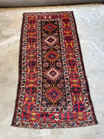 Full view of antique Kazak runner with tribal symbolism in vibrant colors.