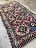 Tribal Kazak wool runner with navy blue, ivory, and terracotta color palette.