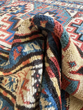 Vintage hand knotted Kazak runner with strong tribal geometric patterns.