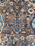 Elegant vine work flowing across the field of antique Kerman rug.