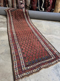 Antique Persian Kurdish runner with flame boteh design on chocolate brown ground.
