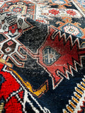 1920s antique tribal rug displaying a
scattered patina and low pile.