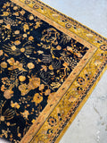 Marigold yellow border detail framing a midnight blue antique rug.
