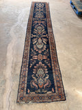 Navy blue antique runner rug from early 1900s Persia laid out to show its long, narrow proportions.