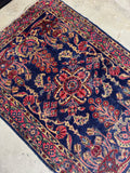 Vintage Persian Lilihan rug with deep navy ground and flowing floral bouquets.