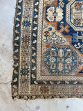 Detail of colorful border with random pops of orange and blue on Caucasian rug.