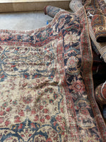 Detail of the rug’s corner showing wear patterns and color contrast.