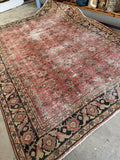 Antique Mahal village rug with all over floral design on warm brick red ground.