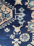Animal motif detail on antique Malayer rug woven into navy field with small scale pattern.