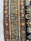 Border detail of antique Persian Malayer rug with repeating floral design and warm  and neutral tones.