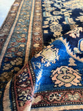 Corner spandrel detail on 1920s Malayer rug with navy ground and tribal accents.