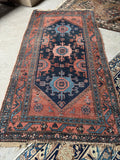 Overall shot of tribal Persian Malayer rug with scattered wear and low wool pile.
