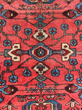 Tribal geometric Persian rug featuring stylized floral branches and central medallions.