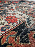 Vintage Persian Kurdish rug with pops of electric tang orange and rich navy blue accents.