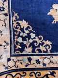 Vintage Chinese blue area rug close-up showing authentic age-related wear, low pile, and exposed foundation.