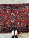 Antique Persian Heriz rug. Vintage wool gallery carpet with stepped medallions, rich crimson tones, and a beautifully detailed midnight blue border.