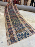 Antique Persian runner with lattice field and stylized shrubs on navy and coffee brown ground.