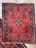 Small Persian entryway rug in coral and navy blue with hand woven floral details.