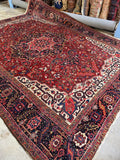 Oversized antique Persian Heriz rug with saturated vegetable dyes and tribal energy.