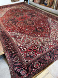 Antique Persian Heriz rug with oversized geometric medallion in a 12' x 20' size.