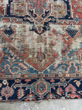 End detail of antique Heriz rug with small restoration patch.
