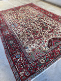Antique Persian Heriz rug with ivory ground and watermelon red border.