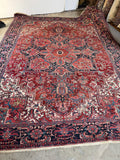 Vintage 10x14 Persian Heriz area rug. 1920s geometric wool carpet featuring an ombré medallion, ivory spandrels, and rich vegetable-dyed colors.