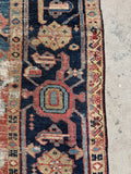 Side border detail of antique Heriz rug with small patch repair.