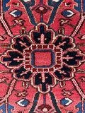 Close up of a rich central medallion in an Antique Persian Heriz rug.