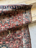 Antique Karaja Persian runner with terracotta red field and angular tribal floral motifs throughout.