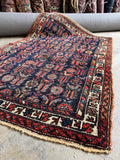 Kurdish rug with chicken and peacock motifs woven across a deep navy field.