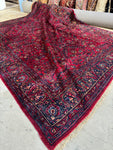 Antique Persian Lilihan rug with deep ruby red background.