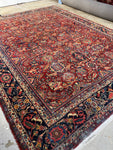 Antique Persian Mahal rug with warm red field and floral patterns.